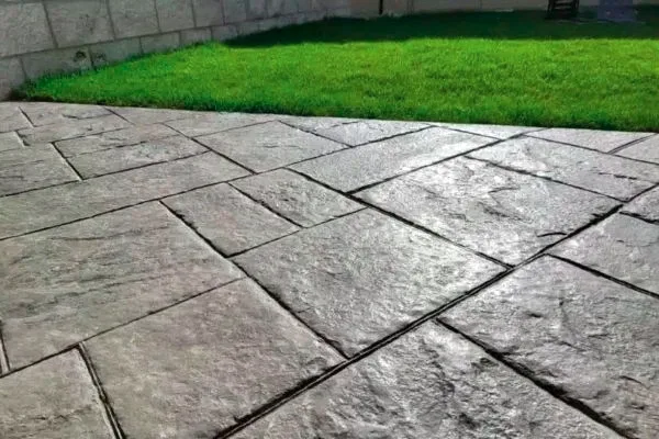 Pavimento de hormigón impreso con molde de piedra gris en jardín de Bilbao
